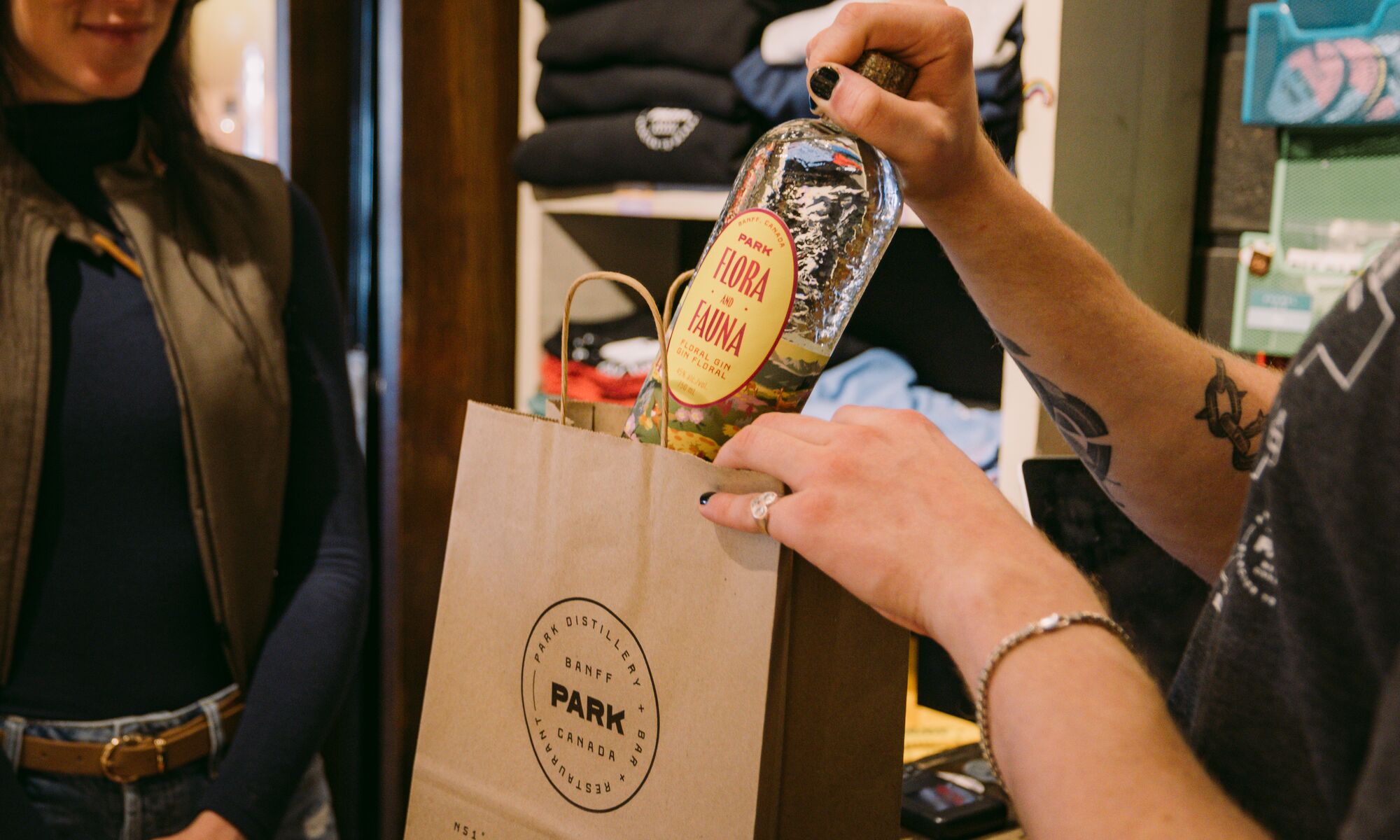 A woman buys a bottle of gin at the PARK Distillery retail store. 